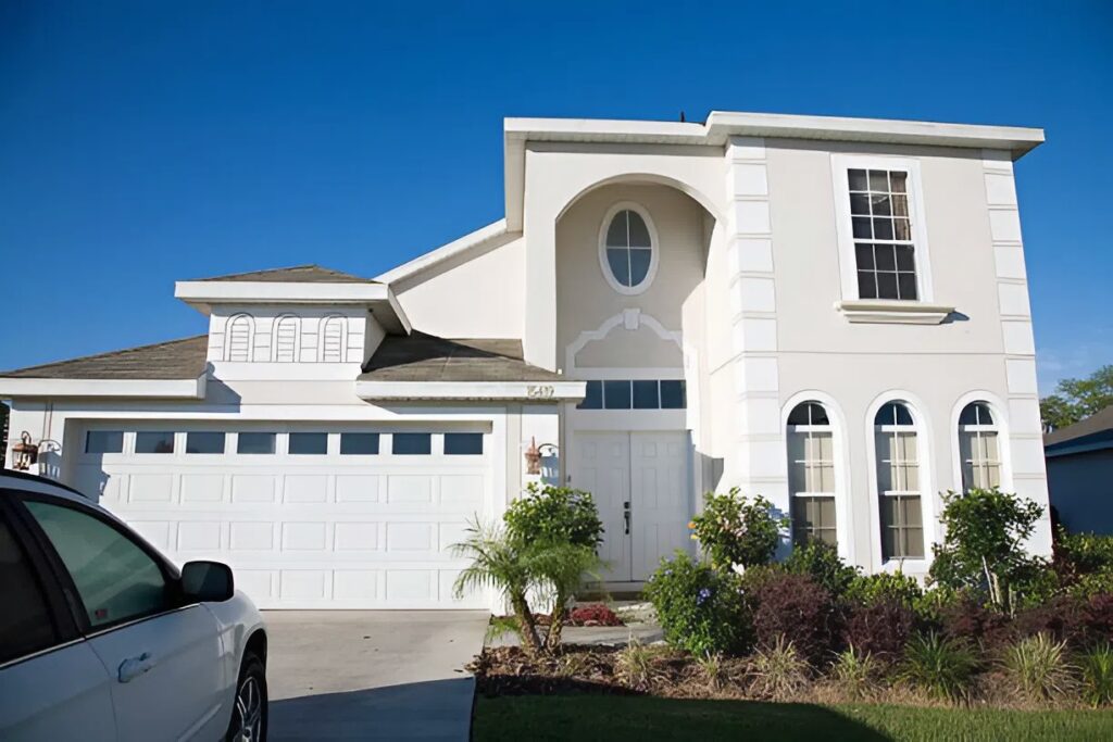 Freshly painted soft beige two-story home completed by a house painter in Orlando, FL, under bright Florida sunlight